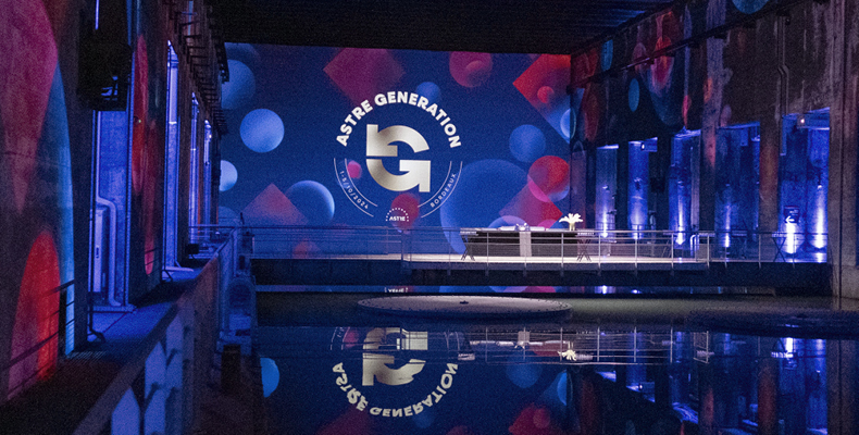 Logo Astre Génération en projection immersive sur les murs du Bassin des Lumières à Bordeaux